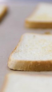 Place bread on a baking tray to toast. Soft bread slices placed on a right wooden tray isolated