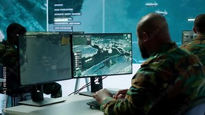 Military crew in a high tech operations command post managing information from radar cctv systems, real time data to support defense missions. Army protocols for national security. Camera A.
