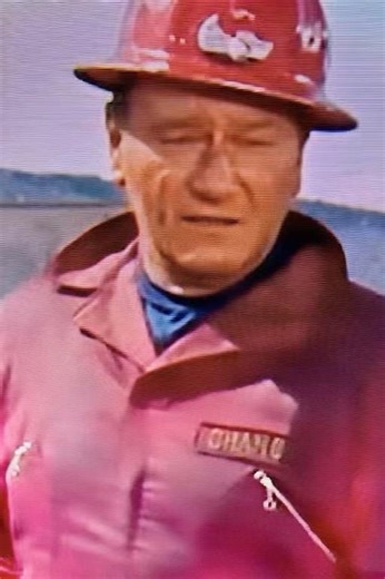 JOHN WAYNE DRINKING COFFEE ON THE SET OF “HELLFIGHTERS”