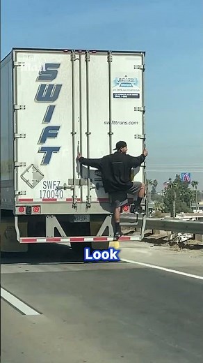 Daring hitchhiker rides on the back of a truck
