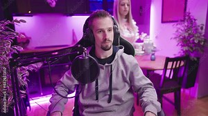 Cute personal maid in pink uniform serving male gamer tea kitchen in background 4K