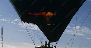 Slow motion close up of vibrant flame igniting inside colorful hot air balloon as it inflates before takeoff at 1000 fps. A symbol of life, liberty, happiness, and the spirit of travel. Stock Video