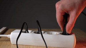 connecting electrical equipment to an outlet, charging a phone, inserting a plug into an outlet, connecting electrical appliances to an extension cord