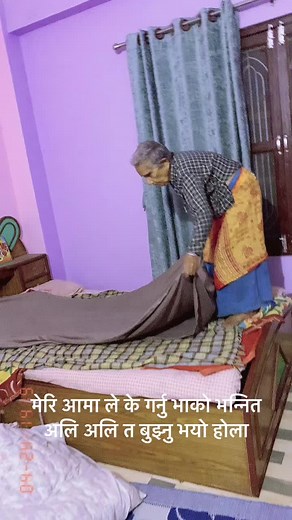 Elderly Woman in Traditional Attire Organizing Bed