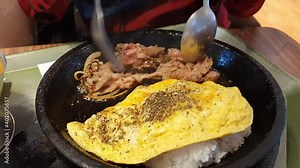 Creamy cheese curry omelet rice with bulgogi steak or burger patty on hot plate, Asian cuisine culinary