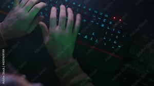 The programmer's hands use and click on the mouse, quickly type on the keyboard, coding, programming,developing, inputing information in the light of the lamp, the person works on the computer