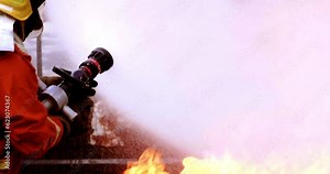 Firemans are using water in fire fighting operation extinguish fire with the hose. Burning house fire drill. High quality 4k footage