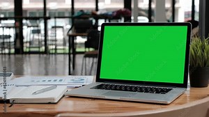 Chroma key green screen laptop computer set up for work on a office desk.