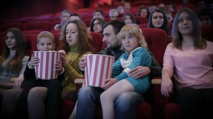 Family enjoying a movie at the cinema, medium shot - Free Stock Video