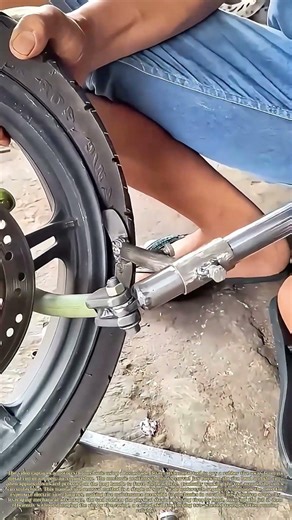 Prying the Rubber: How a Mechanic Uses a Custom Tool to Remove a Motorcycle Tire from Its Rim