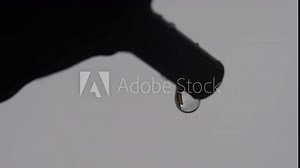 A precise macro look at two water drops hanging on a plastic tube, both of them reflecting the background. A valid illustration of water surface tension