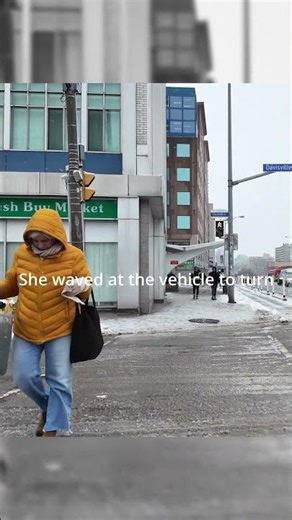 Lady waves at vehicle to turn as pedestrians are crossing in Toronto