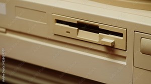 Using diskette for old computer. Music recorder, playing retro computer games. Vintage device for office, obsolete technology.