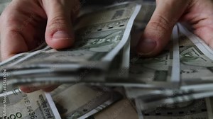 Woman's hands counting brand new indian 500 rupees banknotes.