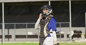 Disappointed caucasian female baseball player, taking off helmet and walking off field after game