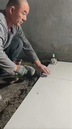 the process of installing rectangular ceramic tiles on the floor in a room in a building #popular