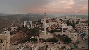 Aerial camera footage of a city with a mosque and surrounding hills in Jerusalem Drone