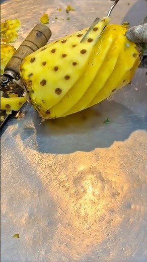 Skillful pineapple carving creating elegant spiral patterns with precision and artistry