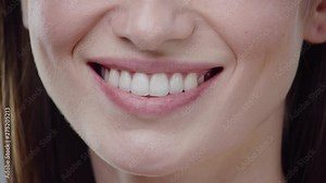 Woman mouth smiling happy beautiful soft lips showing healthy teeth dental lead by hand on the face attractive female happy health cosmetics close up slow motion