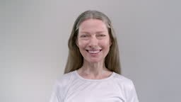 face of old happy smiling woman. Senior female in the white studio...
