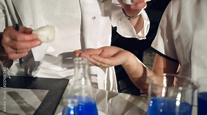 two technicians are performing tests with chemicals and liquids in test tubes at the hospital. Experiments in a chemistry lab. Close-up
