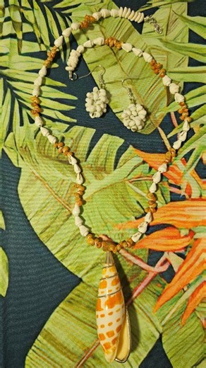 A 23-inch necklace of white puka shells and other tiny seashells leading to an attached seashell pendant wrapped in sterling silver. The necklace closes with a silver-toned lobster claw clasp. Comes with matching white mongo seashell drop, pierced earrings. Designed and made in Hawaii with aloha by Christie Adams of Christie's Collection of Honolulu, Hawaii. | Christie Adams