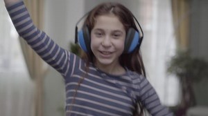 Portrait happy girl with headphones dancing and listening to the music