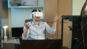 Male scientist designer wearing VR headset while working with engineering project in lab with 3d three dimensional printing. Modern technologies