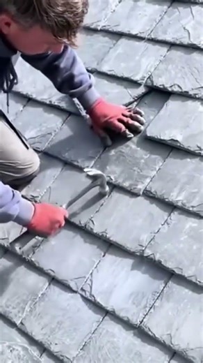This is one way that construction workers shift a sagging roof tile on a building's roof.