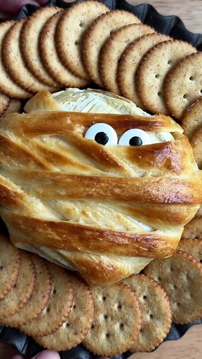 In need of an easy Halloween appetizer? Enter: Mummy Baked Brie! Slice a wheel of baked brie in half and fill it with brown sugar, cinnamon and chopped pecans (or jam, if preferred!). Use Essential Everyday crescent roll dough to wrap around the brie to create the mummy look, then bake at 400˚F until golden brown and melty! #halloween #halloweenrecipe #bakedbrie #brie