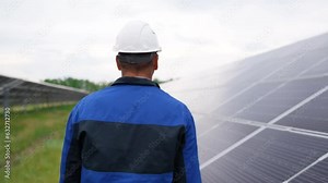 Service Engineer or electrician goes by solar panels, working and solving problem for green energy solar power plant operation. Technician maintenance solar cells on Solar Energy Plant