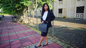 Woman in business attire stands over walkway