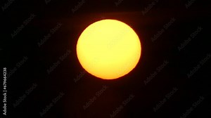 Dark and red sky and yellow solar disk with Atmospheric refraction. Sun with distorted shape of sphere caused by atmospheric optical phenomenon - real time.