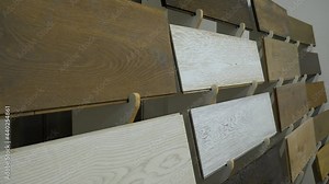 Samples of laminate on a stand of different wood textures in a flooring store
