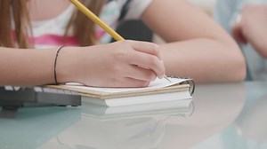 Girl writes notes while learning in classroom - Free Stock Video