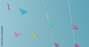Vibrant pennant flags strung against a clear blue sky with the sun shining brightly.