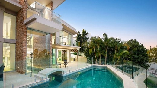 Gold Coast mansion has a pool that starts at the outdoor terrace and flows into the kitchen