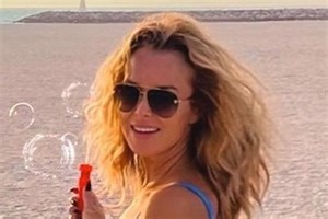 Amanda Holden, 50, blows bubbles as she shows off toned bod in blue bikini