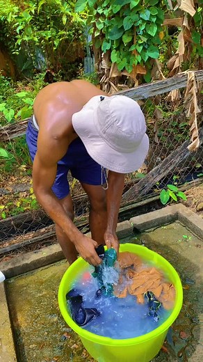 Hardworking Handsome Man Washing Clothes with Scrubbing Board