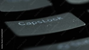 Keyboard button CAPSLOCK. Macro shot of finger pressing CAPSLOCK button