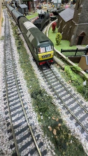 Class 47 pulls a passenger train down the back straight.