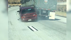 Watch: Truck drags car with driver still in it