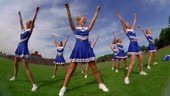Slow motion low angle wide shot pan teen female cheerleaders in...