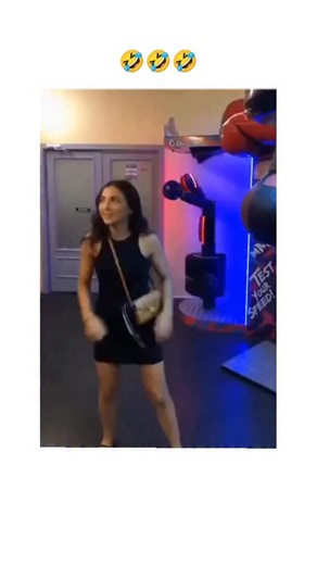 Repostspmo | The video in the post features a young woman in a black dress delivering a powerful punch to an arcade boxing machine, achieving a high... | Instagram