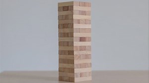 Stop motion animation Game with wooden blocks on white background. Wooden beams puzzles jenga gather in one tall tower. Stop motion.