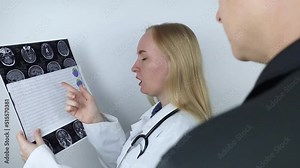 Epileptologist examines patient MRI and electroencephalogram. Concept treating epilepsy and helping people who suffer from this disease. Neurologist at work. Pathology of the brain. Seizure activity