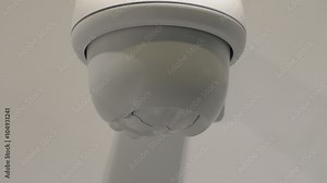 CCTV camera fixed on white wall rotating operating