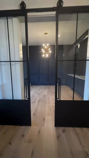 Wow! We can’t get enough of this stunning study. The black metal barn doors by Rustica are our favorite feature - what’s yours? | Biringer Builders
