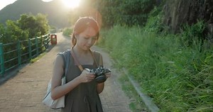 Woman use camera to take photo with nature background