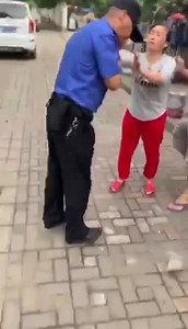 Chinese police officer takes brick to the head.